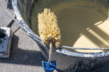 Paint roller and metal bucket with paint for house renovation