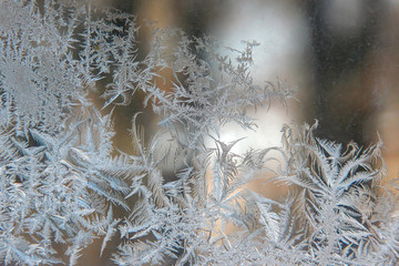 frosty patterns on the window glass closeup. natural textures and backgrounds. ice patterns on...