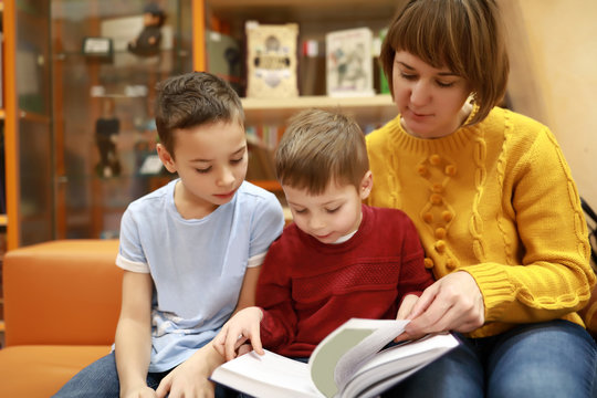 Mother with sons reading book