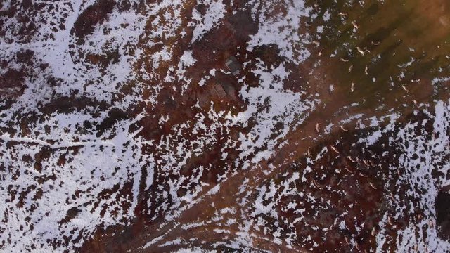 4K Aerial View of Drone Closing in on a Reindeer Herd Running Along the Snow Covered Barren Landscape in Bj&ouml;rkliden, Abisko National Park, Sweden.