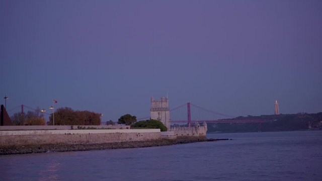 Lisbon Belem Tower at sunset with tagus river and Christ statue on background 4K