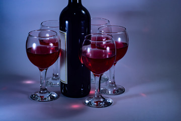 Bottle and glasses of red wine in a romantic setting in the evening