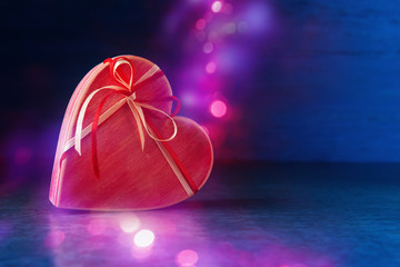 Pink heart shaped gift box with holiday defocused lights. Valentines day concept
