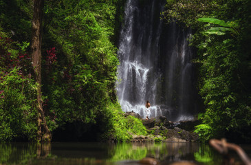 Fototapeta na wymiar Woman near Labuhan Kebo Waterfall located in Munduk, Bali