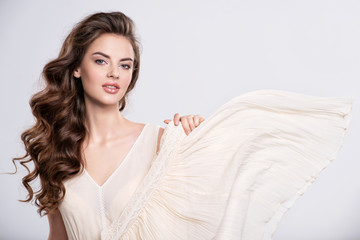 Portrait of a beautiful woman with a long hair in a beige dress.