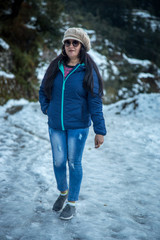 Happy Indian Woman enjoying her first snowfall during winter holidays in India.