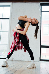 attractive woman touching face while dancing jazz funk