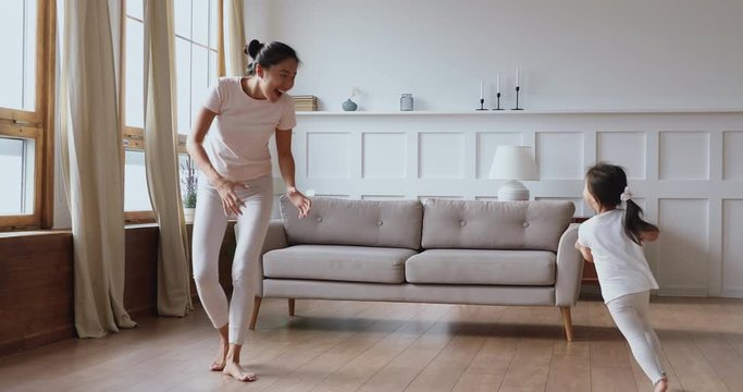 Happy asian mother and daughter having fun in living room