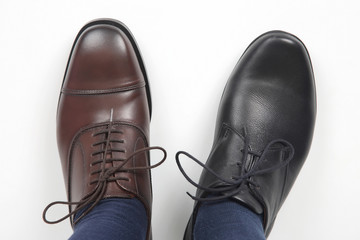 Men's feet in different color classic shoes on white background