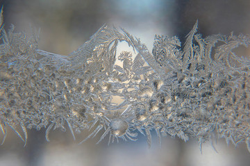 frosty patterns on the window glass closeup. natural textures and backgrounds. ice patterns on...