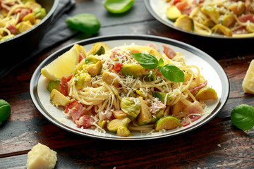 Homemade Brussels sprouts, bacon, pancetta pasta with parmesan cheese. On wooden table