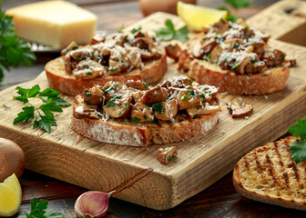 Grilled mushroom toast with parsley, lemon and parmesan cheese on wooden board. healthy vegan food