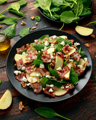 Bacon, Apple Salad with spinach, walnuts and feta cheese. on wooden table. healthy food.