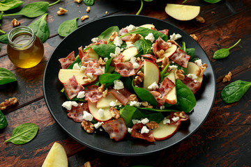 Bacon, Apple Salad with spinach, walnuts and feta cheese. on wooden table. healthy food.