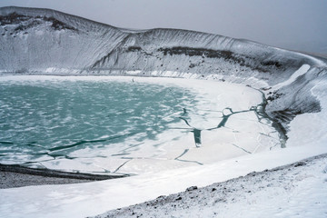 Ovelooking ice covered Viti volcanic crater near Krafla geothermal area in Iceland. Foggy and snow...