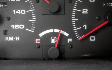 Fuel indicator needle in focus ,dirty dashboard on old used japanese car.