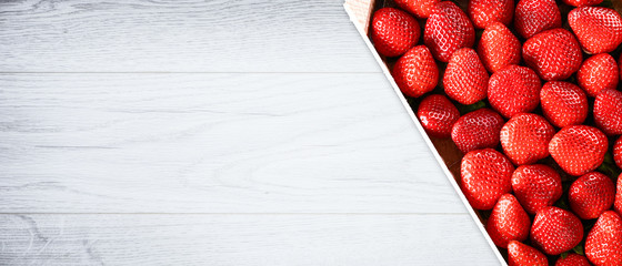 Strawberries in box top view on white rustic table. Beautiful forest juicy strawberry top view Copy...