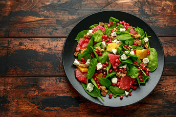 Orange Grapefruit salad with spinach, walnuts, pomegranate seeds and feta cheese. healthy food