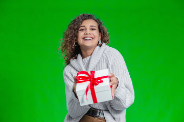 Gift box in hands of girl with curly hair, celebrating her birthday party.