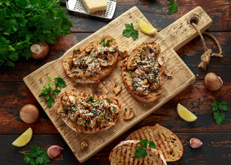 Grilled mushroom toast with parsley, lemon and parmesan cheese on wooden board. healthy vegan food