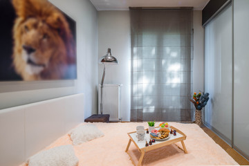 Interior of bedroom in modern flat. King size bed. Window with curtain.