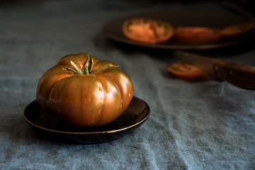 dicke fleischige tomaten auf teller mit aufgeschnittenen scheiben
