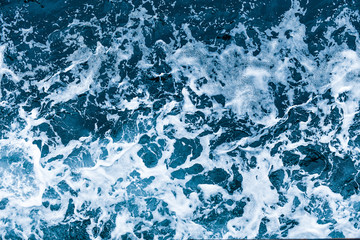Aerial view of salt ocean waves. Blue water aqua sea background ot texture. Rippled spashing waves.