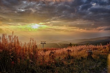 Fototapeta premium Sunset on ski slope in autumn mountains. Wonderful colors of nature and sky.
