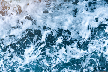 Fototapeta na wymiar Aerial view of salt ocean waves. Blue water aqua sea background ot texture. Rippled spashing waves.