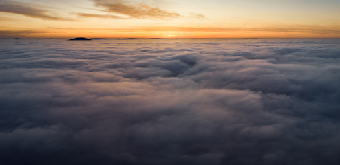 Fototapeta na wymiar Beautiful panoramic sunrise above clouds from airplane perspective.