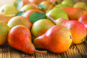 Fresh pears on wooden background. Red yellow pear fruits at the table.
