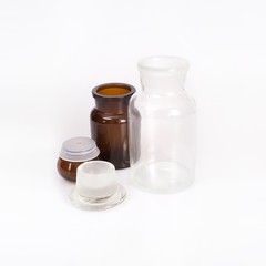 Brown and transparent glass jars for laboratory medical research isolated on white background.