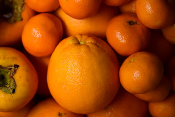 Orange fruits close-up. Oranges, tangerines and persimmons.