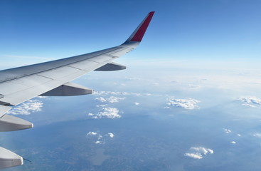 plane wing and cloud floating on sky through window frame