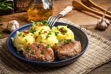 Meatballs served with boiled potatoes.
