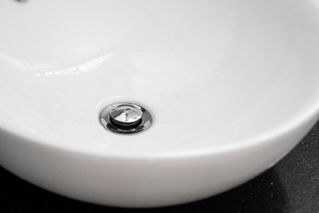 Bathroom interior with white round sink and chrome faucet in a modern bathroom.