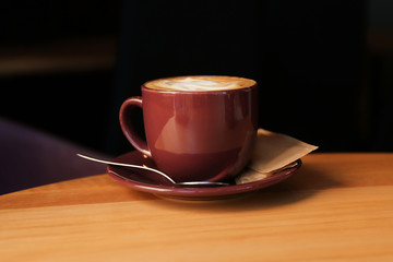 Aromatic coffee on wooden table in cafe