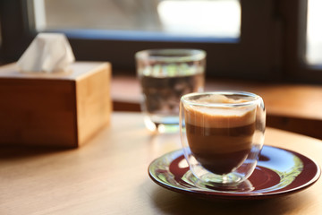 Aromatic coffee on wooden table in cafe. Space for text