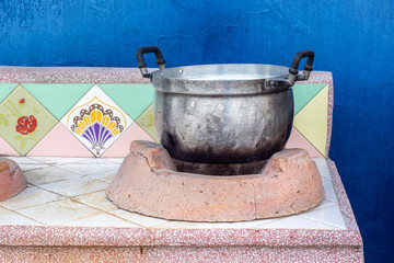 Old aluminum pot on vintage polished stone stove