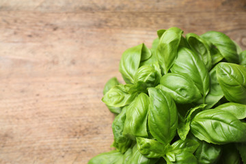 Fresh basil on wooden table, top view. Space for text