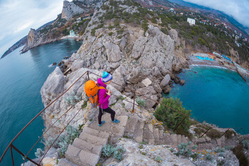 A woman descends the steps from the top of the mountain.