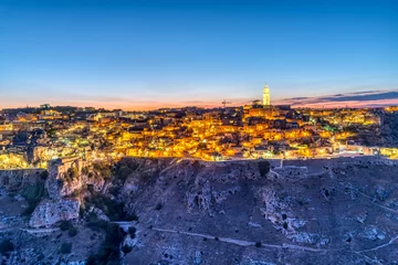 Foto op Aluminium View of the beautiful old town of Matera and the canyon of the Gravina river after sunset © elxeneize