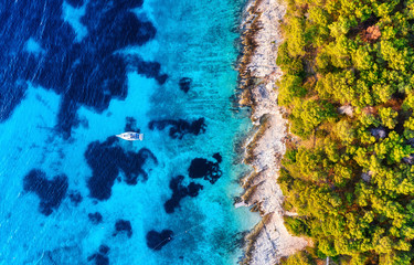 Blue water background and coast with forest from top view. Yacht on the water surface from top view. Summer seascape from air. Croatia. Travel - image