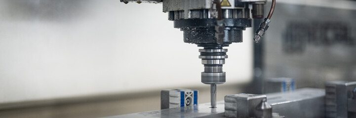 Fräse in Verwendung hinter einer Plexiglas. Dreher bearbeitet Aluminium. CNC Maschine