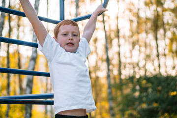 Fototapeta premium Red-haired boy doing sports exercises on the street