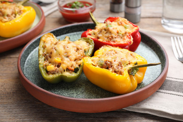 Tasty stuffed bell peppers served on wooden table, closeup