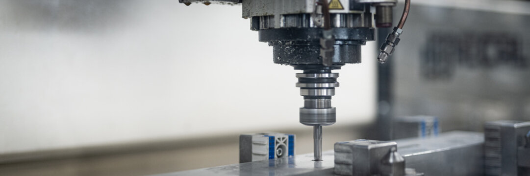 Fr&auml;se in Verwendung hinter einer Plexiglas. Dreher bearbeitet Aluminium. CNC Maschine