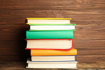 Stack of colorful books on wooden table
