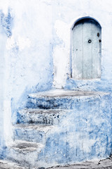 Stone staircase with old, wooden, blue door in Chefchaouen, Morocco.