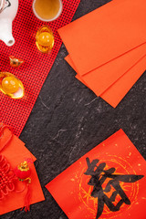 Fototapeta na wymiar Design concept of Chinese lunar January new year - Festive accessories, red envelopes (ang pow, hong bao), top view, flat lay, overhead above. The word 'chun' means coming spring.